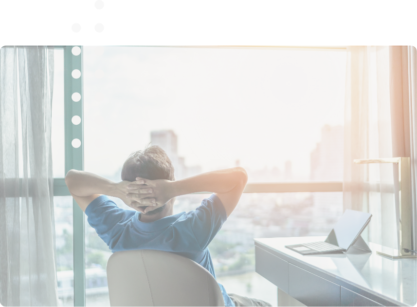 PeaceofMind.png Entspannte Person lehnt sich nach der ISO27001 Implementierung in ihrem Schreibtischstuhl zurück und schaut aus dem Fenster.